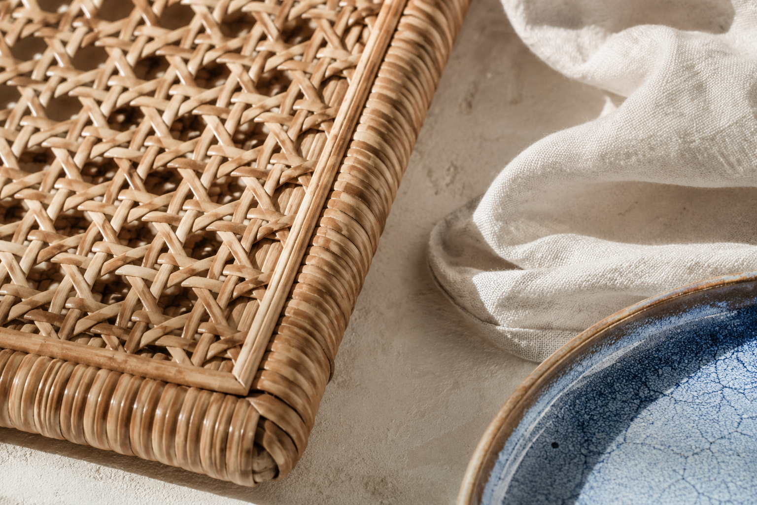 Rattan weave, white linen and blue glazed ceramic detail